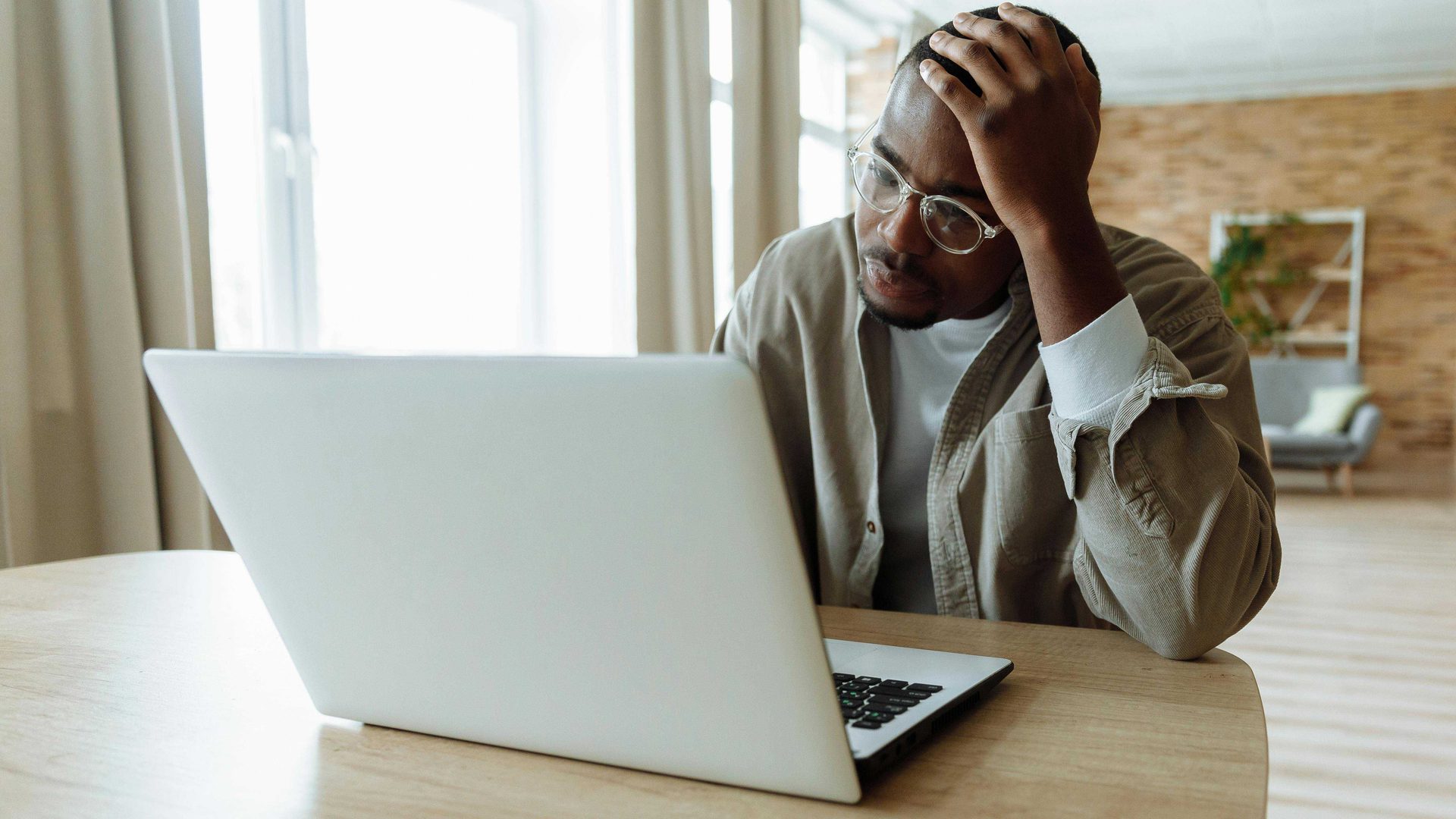 Person with head resting on hand looking at computer screen