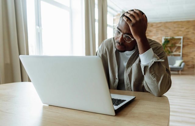 Person with head resting on hand looking at computer screen